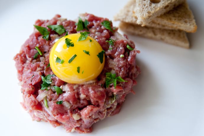 raw meat with an egg and toast