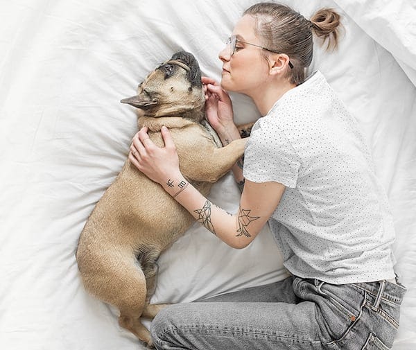 Girl co-sleeping with a dog in the bed